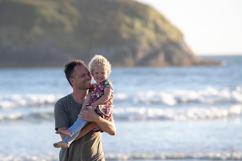 Father and daughter on the beach during their family photos in Tofino. Photography by Kaitlyn Shea.