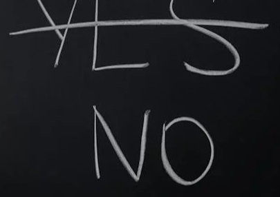 A chalkboard with the word YES crossed out and the word NO underneath