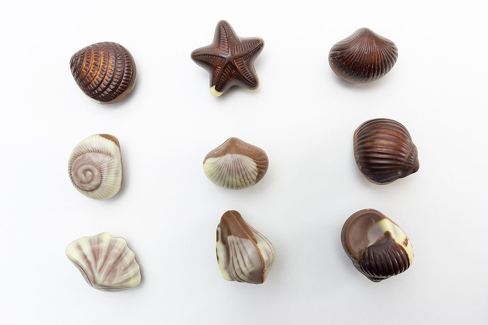 Box of chocolate seashells on white background, a common trigger food for emotional eating and overeating.