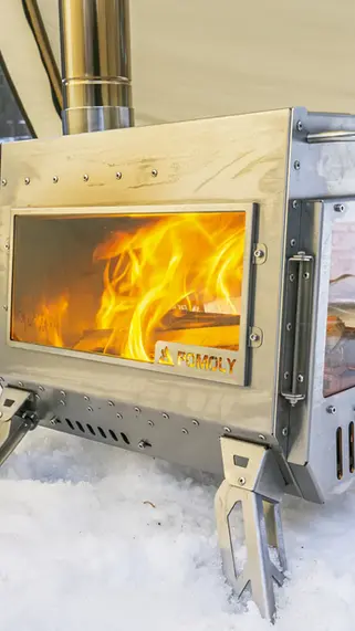 A photo of the Pomoly Dagger stove with a fire inside of it.