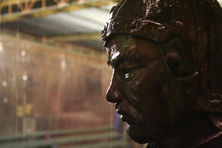 A statue inside a temple at night, seen through heavy rain.