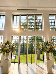 Wedding ceremony entrance with floral arrangements and sunset light at Westwood, Vowery and Estate in Westfield, Indiana