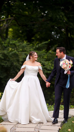 Bride and groom walking hand in hand outdoors after their wedding ceremony at Laurel Hall