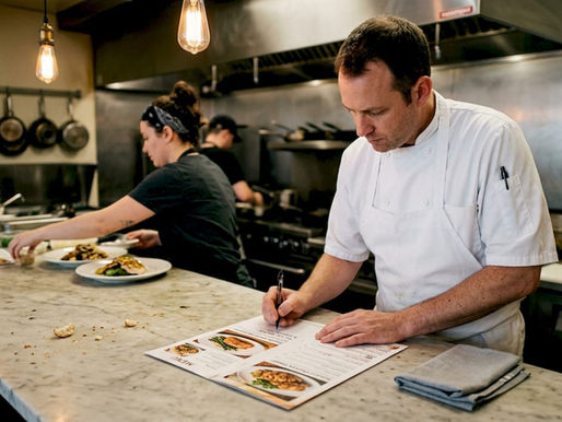 Chef reviewing photo-rich restaurant menu in kitchen