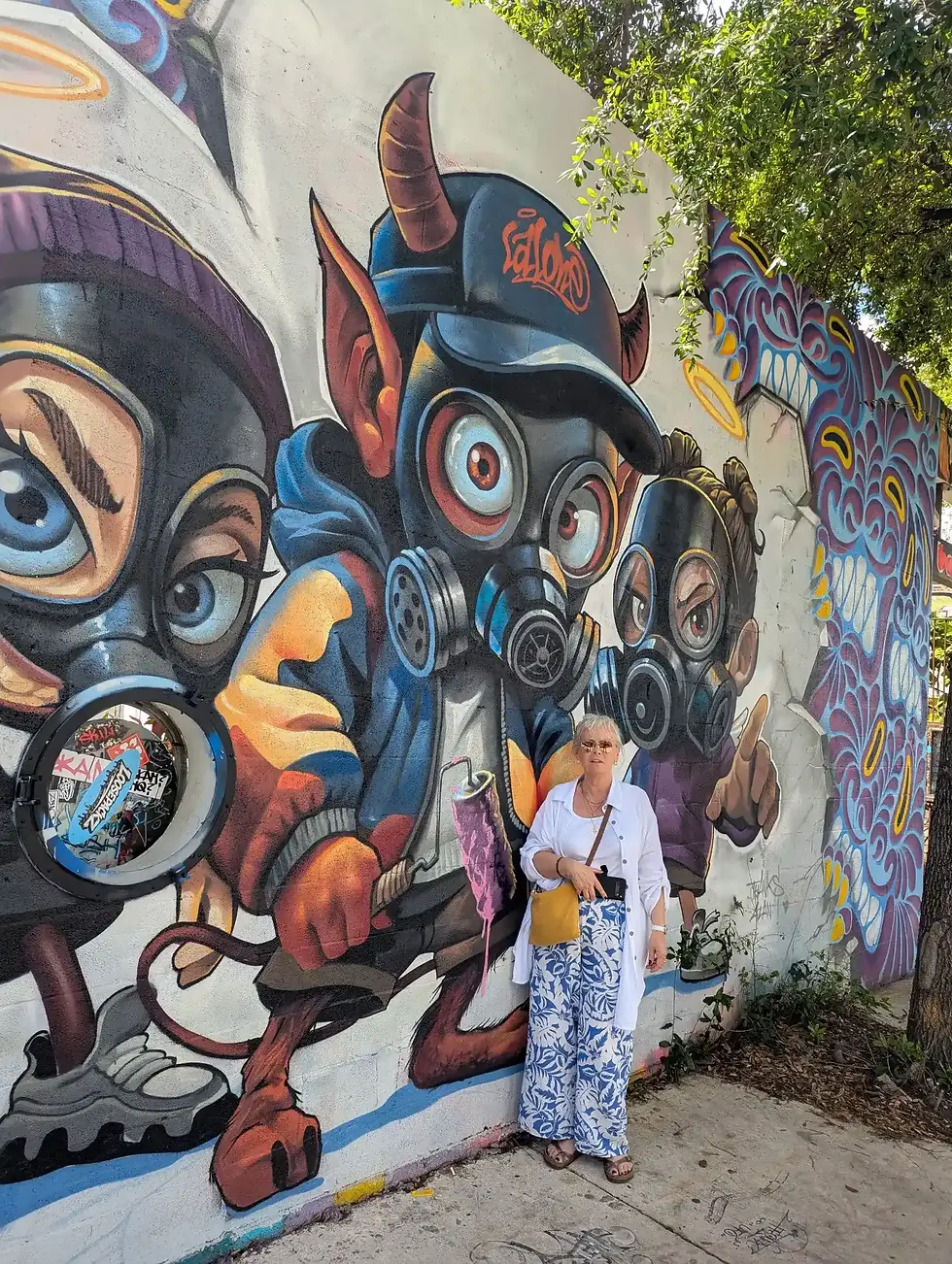 Une visiteuse posant devant une fresque de street art colorée dans le quartier de Wynwood lors d'une visite guidée avec Visite de Miami.