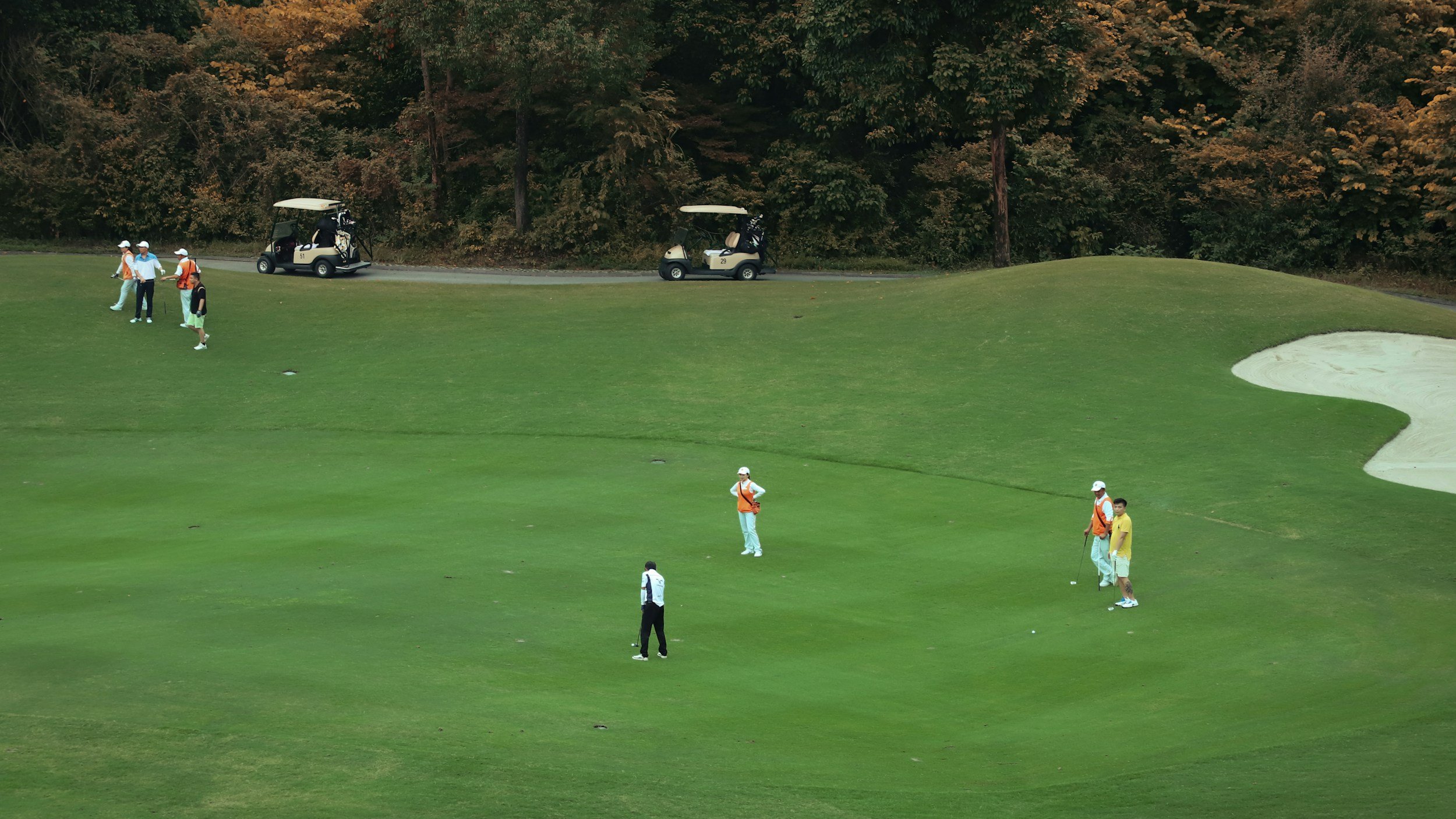 Golfers on the course near sand traps
