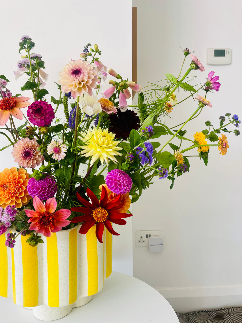 Flowers from the farm in a yellow-striped vase.