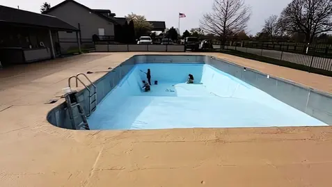 Team members actively painting the pool deck surface at Dye’s Walk Country Club.