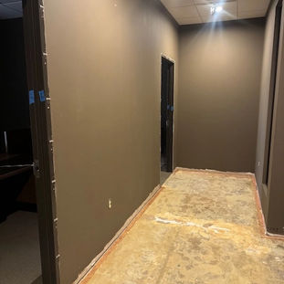 Hallway view showing repaired walls and unfinished flooring after water damage repair.