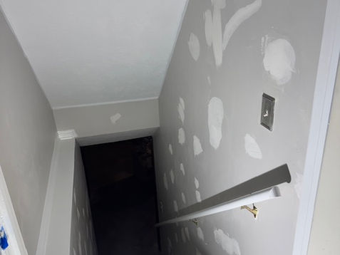 Stair wall with visible wear before prep work for painting.