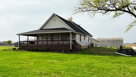 Front of the house with new board and batten siding installed on the lower level, taking shape.
