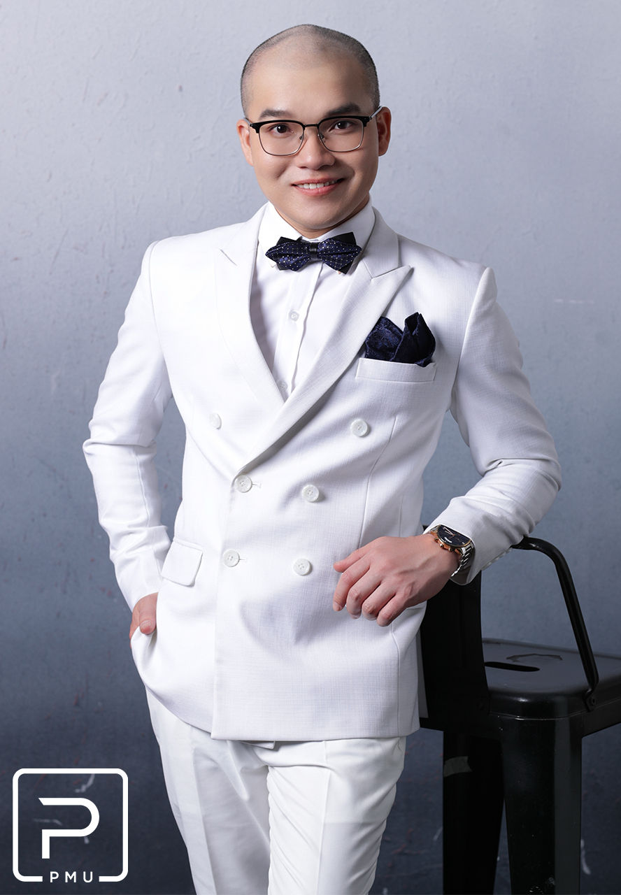 Brian Ho, founder of BrianBrows Beauty Spa & Academy, PMU educator and innovator, posing in a white suit during a professional portrait session in Canada
