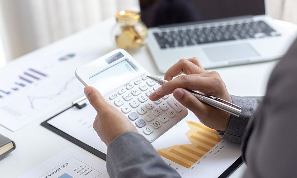 Small business owner using calculator at desk