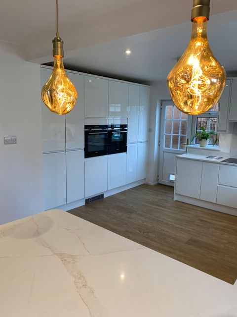 Kitchen island with breakfast bar seating in gloss kitchen