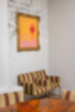 Rincón interior de PABÚ, restaurante con aparcacoches Madrid, con sillones de rayas y cuadro colorido