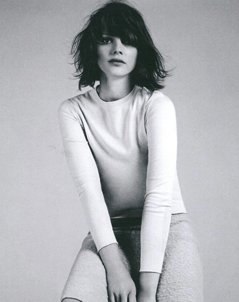 Seated woman with short messy hair looking forward