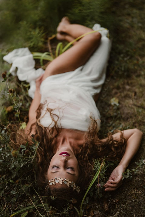 goddess laying in forest surrounded by moss