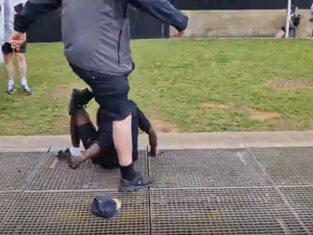 Startling footage depicts a man being kicked and punched in Piccadilly Gardens while a fence is thrown at him during a protest