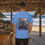 Thumbnail: blue tee shirt with a camping forrest scene with a blue Toyota Land Cruiser and an older dude standing next the FJ40