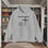 Thumbnail: gray hoodie with Godfidence, Knowing I Can't But He can printed in black with large 3 nail style cross