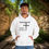 Thumbnail: white hoodie with Godfidence, Knowing I Can't But He can printed in black with large 3 nail style cross