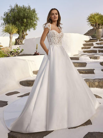 Enzoani Love Everdeen £1695 Introducing the EVERDEEN wedding gown from the Love collection -- a dreamy A-line silhouette crafted in luxurious Mikado or satin fabric. The portrait neckline adds a touch of romance, while the keyhole back design creates an alluring, ethereal feel. Featuring charming pockets for a playful twist, this vintage-inspired bridal dress is ready to walk you down the aisle in style and grace. Feel like a modern princess in the sculptural beauty of the EVERDEEN gown.