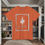 Thumbnail: Orange tee with a large weathered frame with a sword inside with Proverbs 27:17 Iron Sharpens Armor