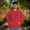 Thumbnail: red hoodie with Godfidence, Knowing I Can't But He can printed in black with large 3 nail style cross