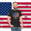 Thumbnail: young man wearing a black t-shirt with a large USA printed in an American flag pattern Made in America Flag background