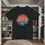 Thumbnail: black t-shirt Old Dudes Club over a beach theme circular back ground