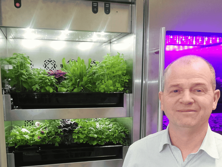 Jason Hirst, Evogro, stood in front of their small vertical farming unit filled with green salads and microherbs
