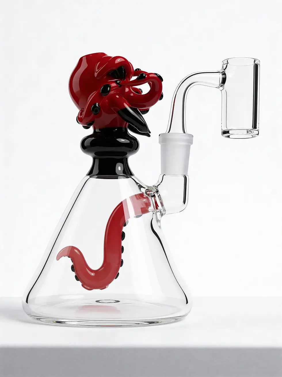 Glass pipe with red and black octopus design on top, clear body with red tentacle inside, on a white surface against a plain background.