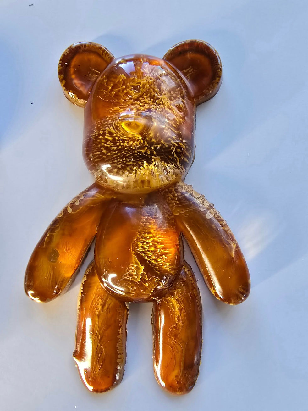 Hand-poured epoxy resin bear. Glossy amber and gold with a chaotic honeycomb pattern. Unique art figure and desk/shelf decor.