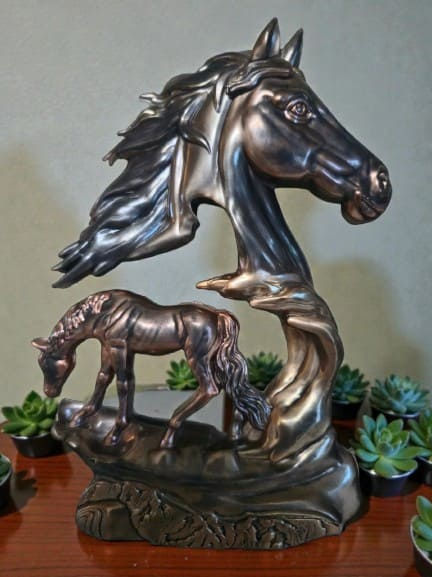 A collection of resin horse sculptures in antique bronze, sterling silver, and midnight onyx metallic finishes.