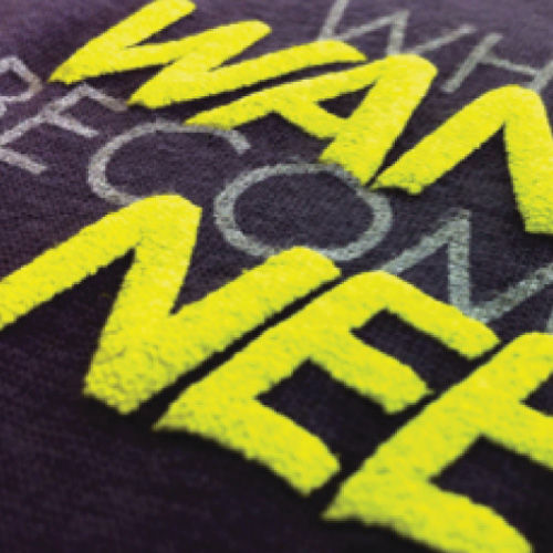 Close-up of raised dimensional puff ink screen printing creating tactile 3D effect on fabric surface