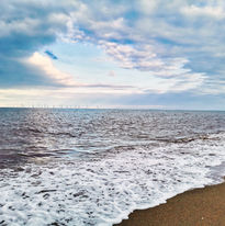 A beautiful picture of the beach with waves lapping onto shore.