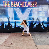 Mia's young daughter dances in front of a colourful mural at The Beachcomber.