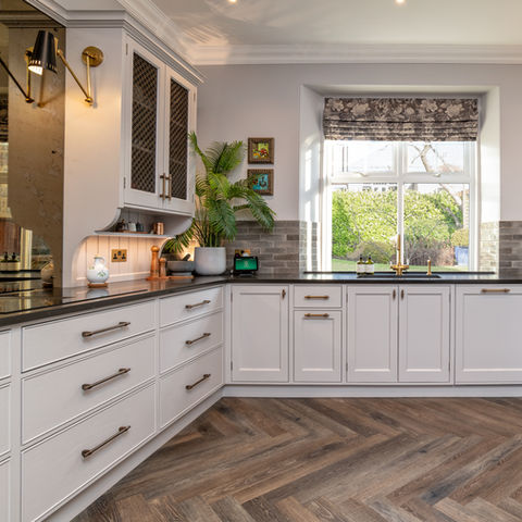 a kitchen with white cabinets and a large window, bespoke kitchen design