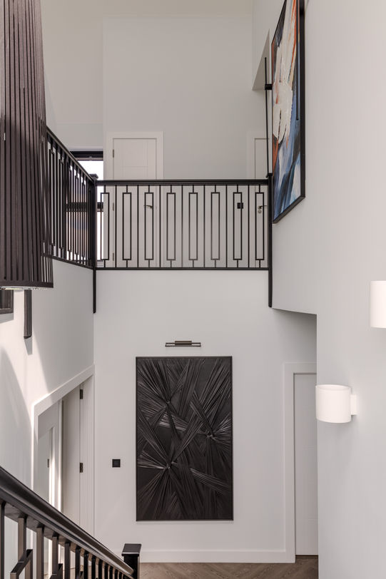 a staircase with a black railing and a black door