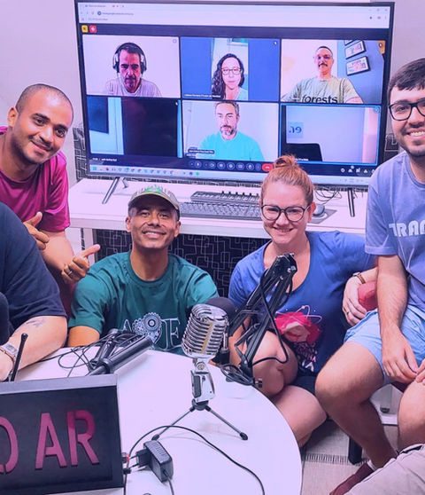 Alunos da Escola de Rádio gravando simulação de podcast em aula prática com microfones