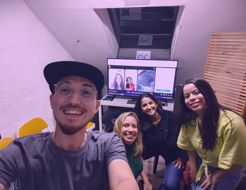 Alunos sorrindo após aula de locução na Escola de Rádio ER+ com equipamentos ao fundo