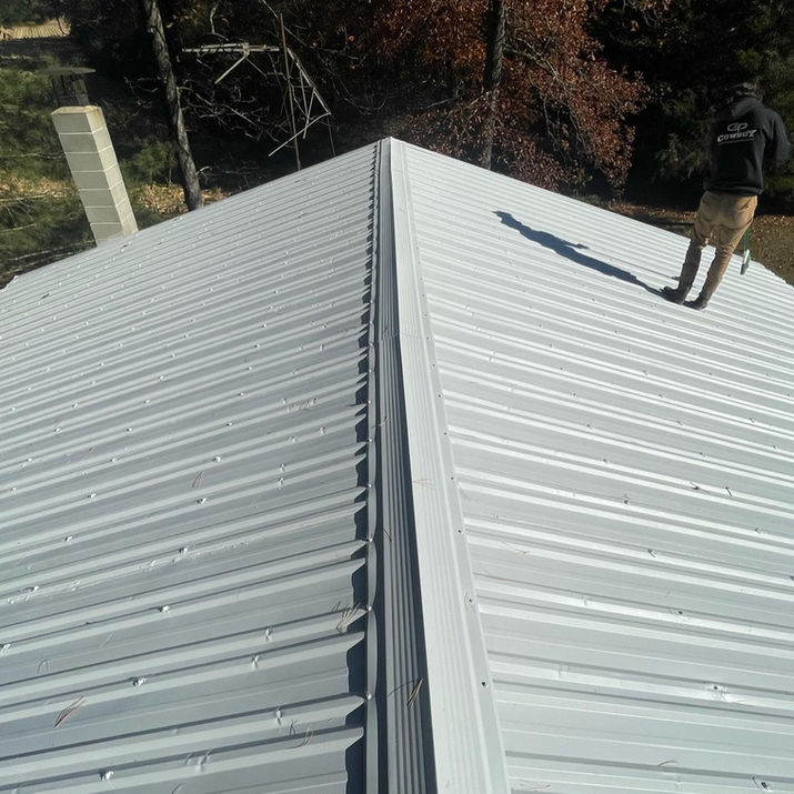 Cowboy Painting Co. applying Uniflex waterproof coating to a metal roof, creating a seamless and durable barrier for long-lasting protection against the elements.