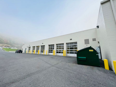 Painting of a large auto mechanic shop, with industrial-grade coatings applied to walls and surfaces for durability in a high-traffic environment.