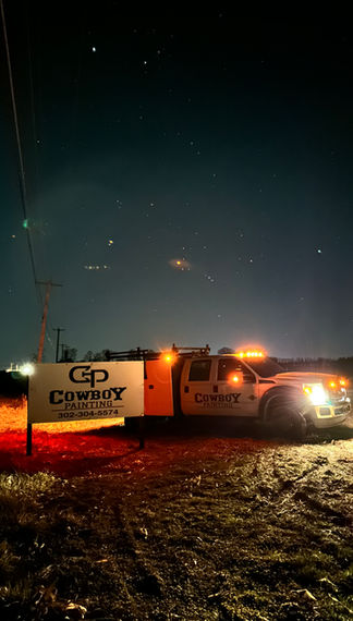 Cowboy Painting Co. fleet truck parked next to the company sign, highlighting our professional branding and readiness for any commercial or industrial painting project.