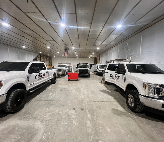 Fleet of vehicles in a painting company’s workshop, awaiting professional paint jobs in a clean and organized space