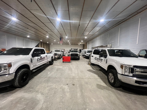 Fleet of vehicles in a painting company’s workshop, awaiting professional paint jobs in a clean and organized space