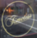 A gold leaf sign on a street-facing window and in script says "Timeless"