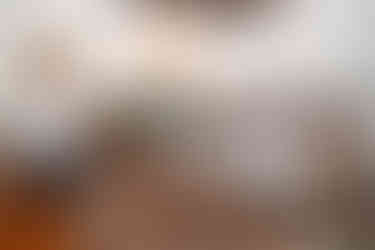 Men meeting, some with hands folded, in a room with Indian flags