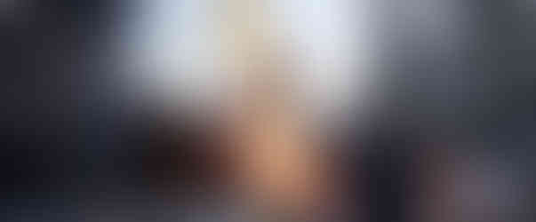 Man watches excavator clearing rubble from Middle East conflict.