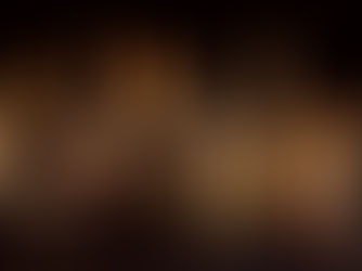 People in robes with flames above their heads gather, praying in a dark setting, conveying a spiritual and solemn mood.